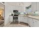 Clean kitchen with stainless steel appliances, white cabinetry, and a corner sink at 1220 Lakeside Dr, Venice, FL 34293