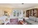 Living room featuring french doors to lanai, wicker furniture, and a decorative rug on carpet flooring at 1220 Lakeside Dr, Venice, FL 34293