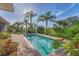 Beautiful pool area surrounded by lush landscaping and a brick walkway at 1220 Lakeside Dr, Venice, FL 34293
