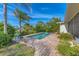 Beautiful in-ground swimming pool with brick patio and lush tropical landscaping under clear, sunny skies at 1220 Lakeside Dr, Venice, FL 34293