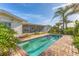 The backyard features a private in-ground pool, lush landscaping, and screened-in lanai at 1220 Lakeside Dr, Venice, FL 34293