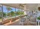 Covered lanai showing outdoor seating, plants, and a view of the pool and the landscaping at 1220 Lakeside Dr, Venice, FL 34293