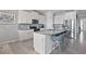 Bright kitchen with white cabinets, stainless steel appliances, an island with seating, and granite countertops at 12637 Promenade Estates Blvd, Sarasota, FL 34238