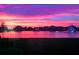 Stunning sunset paints the sky above the lake and neighborhood with a tranquil fountain feature at 12637 Promenade Estates Blvd, Sarasota, FL 34238