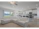 Open concept kitchen, living, and dining areas featuring a large sectional and lake views at 12637 Promenade Estates Blvd, Sarasota, FL 34238