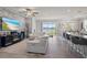 Open floor plan with a stone accent wall, fireplace, and large glass doors that offer backyard and lake views at 12637 Promenade Estates Blvd, Sarasota, FL 34238