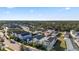 A high-angle view showcasing colorful homes with manicured lawns and tree-lined streets under a sunny sky at 12679 Sagewood Dr, Venice, FL 34293