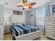 Nautical themed bedroom featuring a queen bed with blue striped comforter and tropical ceiling fan at 12679 Sagewood Dr, Venice, FL 34293