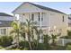 Inviting two-story home with a charming balcony, lush tropical landscaping, and a classic white picket fence at 12679 Sagewood Dr, Venice, FL 34293