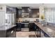 This kitchen features stainless steel appliances, granite countertops, and dark wood cabinets at 12679 Sagewood Dr, Venice, FL 34293