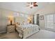 Bright main bedroom featuring a ceiling fan, floral bedding and relaxing coastal decor at 12679 Sagewood Dr, Venice, FL 34293