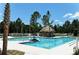 Refreshing community pool with a tiki hut and lounge chairs surrounded by lush landscaping at 12679 Sagewood Dr, Venice, FL 34293