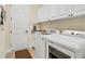 Modern laundry room with washer, dryer, utility sink, and cabinet storage at 13325 Caravaggio Ct, Venice, FL 34293