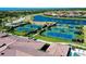 Aerial view of community tennis courts, with a lake, and landscaping, and red tiled rooftops at 13652 Classico Ct, Venice, FL 34293