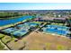 Aerial view of the tennis and pickleball courts, next to a serene lake in a Primary-planned community at 13652 Classico Ct, Venice, FL 34293
