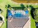 Aerial view of a private pool and hot tub surrounded by manicured landscaping and a screened enclosure at 13652 Classico Ct, Venice, FL 34293