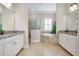 This bathroom features a soaking tub, walk-in shower, and double vanity with granite countertops and tile flooring at 13652 Classico Ct, Venice, FL 34293