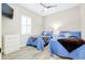 The bedroom features two beds with blue comforters, light wood flooring, and a ceiling fan at 13652 Classico Ct, Venice, FL 34293