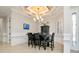 Formal dining room with elegant chandelier, wainscoting, and view to door at 13652 Classico Ct, Venice, FL 34293
