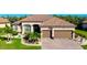 Beautiful single-story home with a brick driveway, two-car garage, and well-manicured landscaping at 13652 Classico Ct, Venice, FL 34293