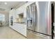 Modern kitchen with stainless steel refrigerator and white cabinetry at 13652 Classico Ct, Venice, FL 34293