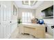 Bright home office featuring a large desk, plantation shutters, and modern decor at 13652 Classico Ct, Venice, FL 34293