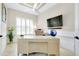 Bright office space with a large desk, plantation shutters, and neutral decor at 13652 Classico Ct, Venice, FL 34293