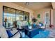 This cozy screened patio features comfortable seating, outdoor decor, and a view of the lake at 13652 Classico Ct, Venice, FL 34293