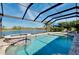 A screened-in pool and spa overlook the lake providing a tranquil outdoor living space at 13652 Classico Ct, Venice, FL 34293