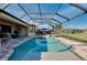 Beautiful pool overlooking the lake featuring screened enclosure, jacuzzi, and brick pavers at 13652 Classico Ct, Venice, FL 34293