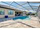 Screened-in pool with brick pavers, jacuzzi, and blue accents overlooks the water at 13652 Classico Ct, Venice, FL 34293
