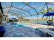 This screened in pool overlooks a tranquil lake and has an outdoor dining area and lounge chairs at 13652 Classico Ct, Venice, FL 34293