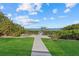 Green grassy backyard leading to a wooden dock overlooking the waterfront with manicured green hedges at 14 Grouper Hole Dr, Boca Grande, FL 33921