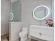 Modern bathroom with sleek vanity, lighted round mirror, and a glass-enclosed shower, creating a spa-like experience at 14 Grouper Hole Dr, Boca Grande, FL 33921