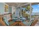 Dining area on screened porch with seating for four and amazing views of the water and dock at 14 Grouper Hole Dr, Boca Grande, FL 33921