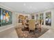 Elegant dining room featuring a wooden table, upholstered chairs, and seamless access to the kitchen and waterfront balcony at 14 Grouper Hole Dr, Boca Grande, FL 33921