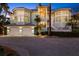 Beautiful home with a spacious driveway, lush landscaping, and a three-car garage at dusk at 14 Grouper Hole Dr, Boca Grande, FL 33921