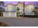 Beautiful home with a spacious driveway, lush landscaping, and a three-car garage at dusk at 14 Grouper Hole Dr, Boca Grande, FL 33921