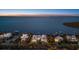 Waterfront home featuring serene water views and tropical landscaping at dusk at 14 Grouper Hole Dr, Boca Grande, FL 33921