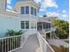 Charming exterior view of a two-story coastal home with lovely landscaping and a white picket fence leading to the home at 14 Grouper Hole Dr, Boca Grande, FL 33921