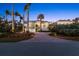 Home featuring a large driveway, lush landscaping, and great lighting at dusk at 14 Grouper Hole Dr, Boca Grande, FL 33921