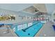 Beautiful indoor pool featuring a competition lane, diving blocks, and ample deck space at 14 Grouper Hole Dr, Boca Grande, FL 33921
