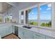 Bright kitchen with stainless appliances, stone countertops, and scenic views from the expansive windows at 14 Grouper Hole Dr, Boca Grande, FL 33921