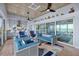 Open living room with stylish blue furniture, decor, and large sliding glass doors offering serene waterfront views at 14 Grouper Hole Dr, Boca Grande, FL 33921