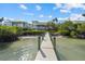 Long dock stretching from sandy beach to the calm, reflective waters, providing direct waterfront access at 14 Grouper Hole Dr, Boca Grande, FL 33921