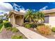 Home entrance featuring a brick walkway, tropical landscaping, barrel tile roofing, and decorative shutters at 142 Palazzo Ct, North Venice, FL 34275