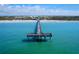 A pier extends into the clear blue-green water with people standing on the end at 150 Fiesole St, Venice, FL 34285