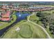 Expansive aerial view of a neighborhood around a pond with golf course; houses have red tile roofs and community features at 162 Treviso Ct, North Venice, FL 34275