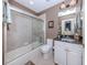 Well-lit bathroom features a shower-tub combo and a vanity with dark granite countertops at 162 Treviso Ct, North Venice, FL 34275