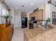 Well-lit kitchen with granite countertops, stainless steel sink, tile floors and black appliances at 162 Treviso Ct, North Venice, FL 34275